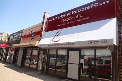 The image shows a storefront with a sign advertising dental care services, including Liberty Dental Care PC and a phone number.